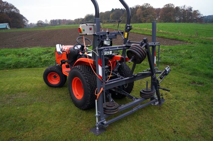 Prototyp des mobilen Divot-Makers „Osnafoot“ in der Dreipunkthydraulik des Pflegeschleppers.