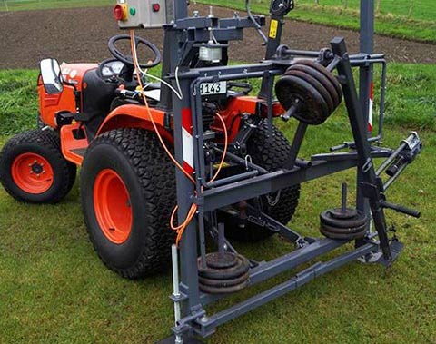 Prototyp des mobilen Divot-Makers „Osnafoot“ in der Dreipunkthydraulik des Pflegeschleppers. 